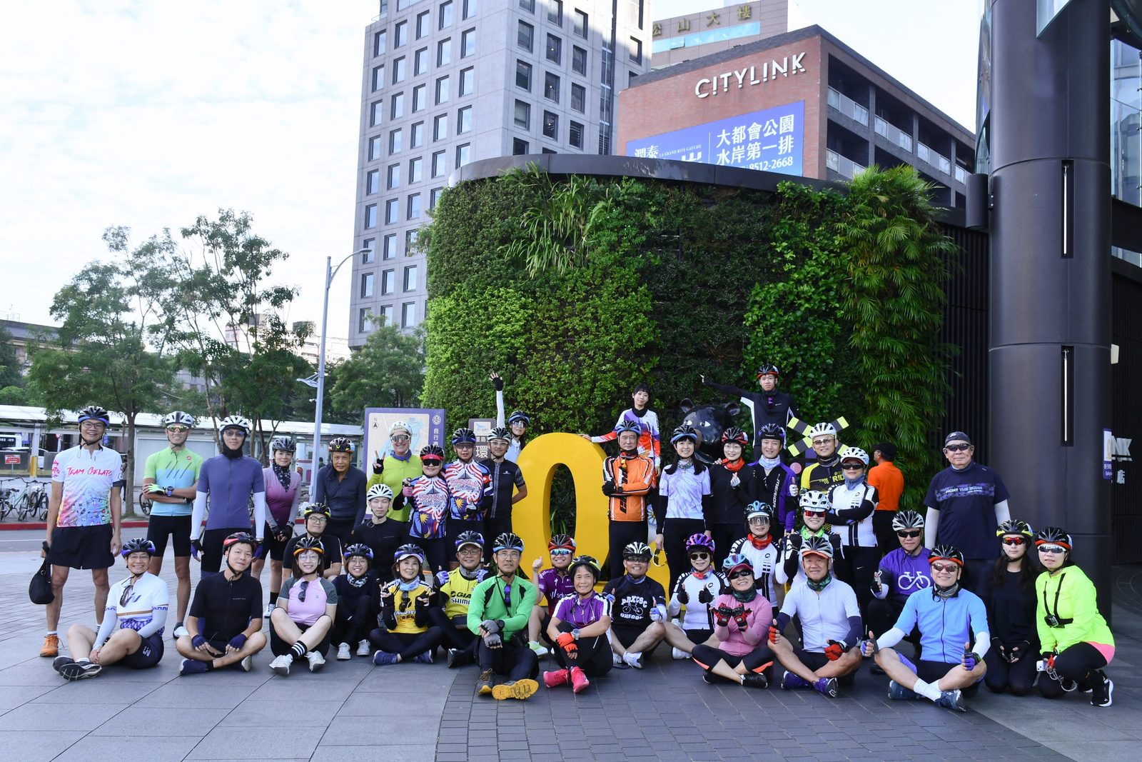 Full group photo at the 0km marker before rollout
