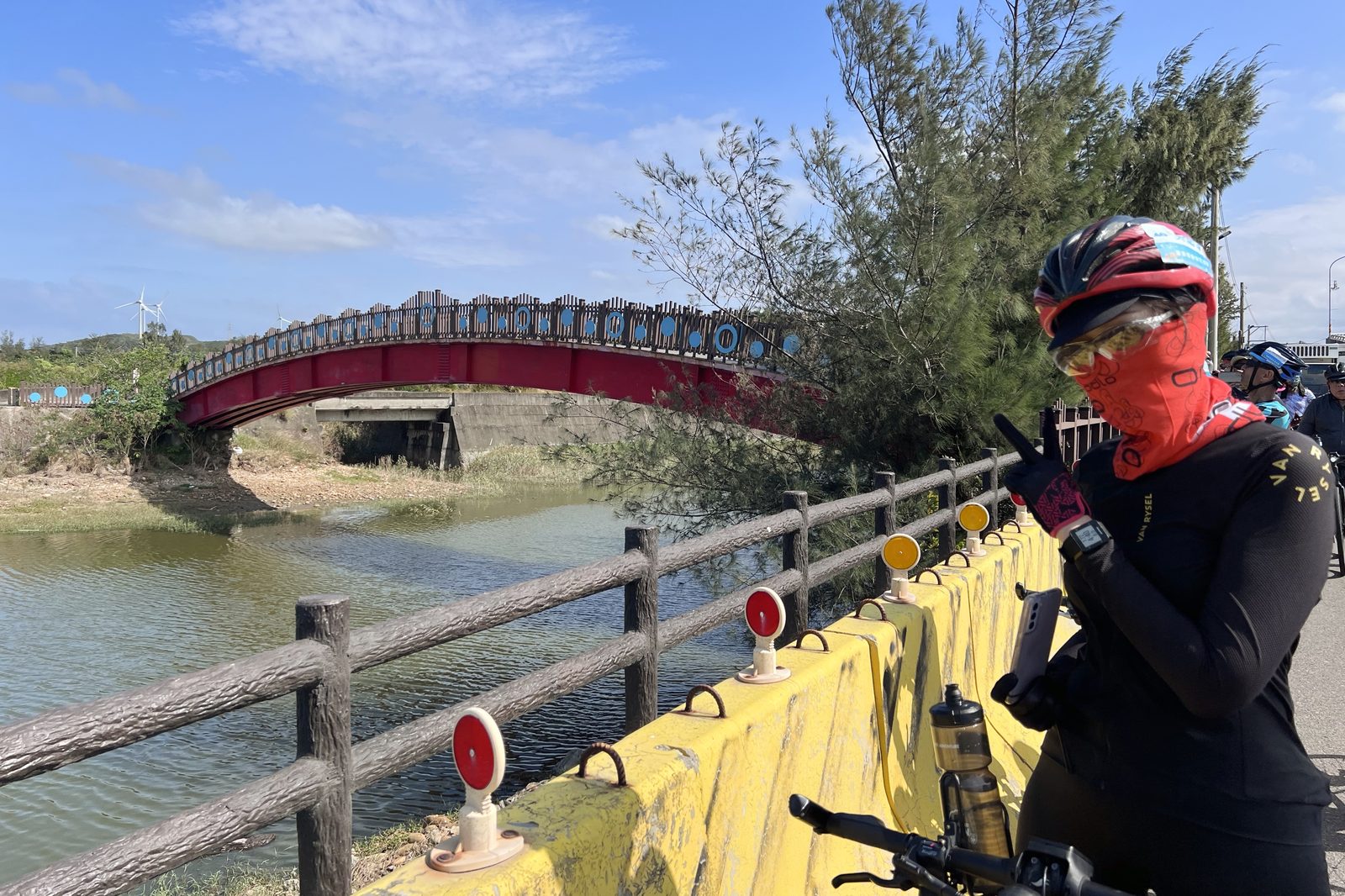 A roadside selfie with a red truss bridge behind