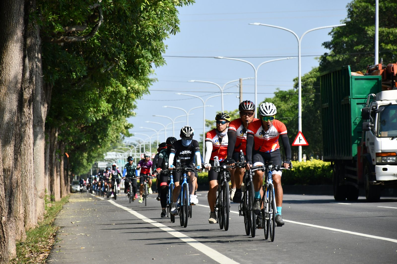 The pack rolling past a truck under shaded trees