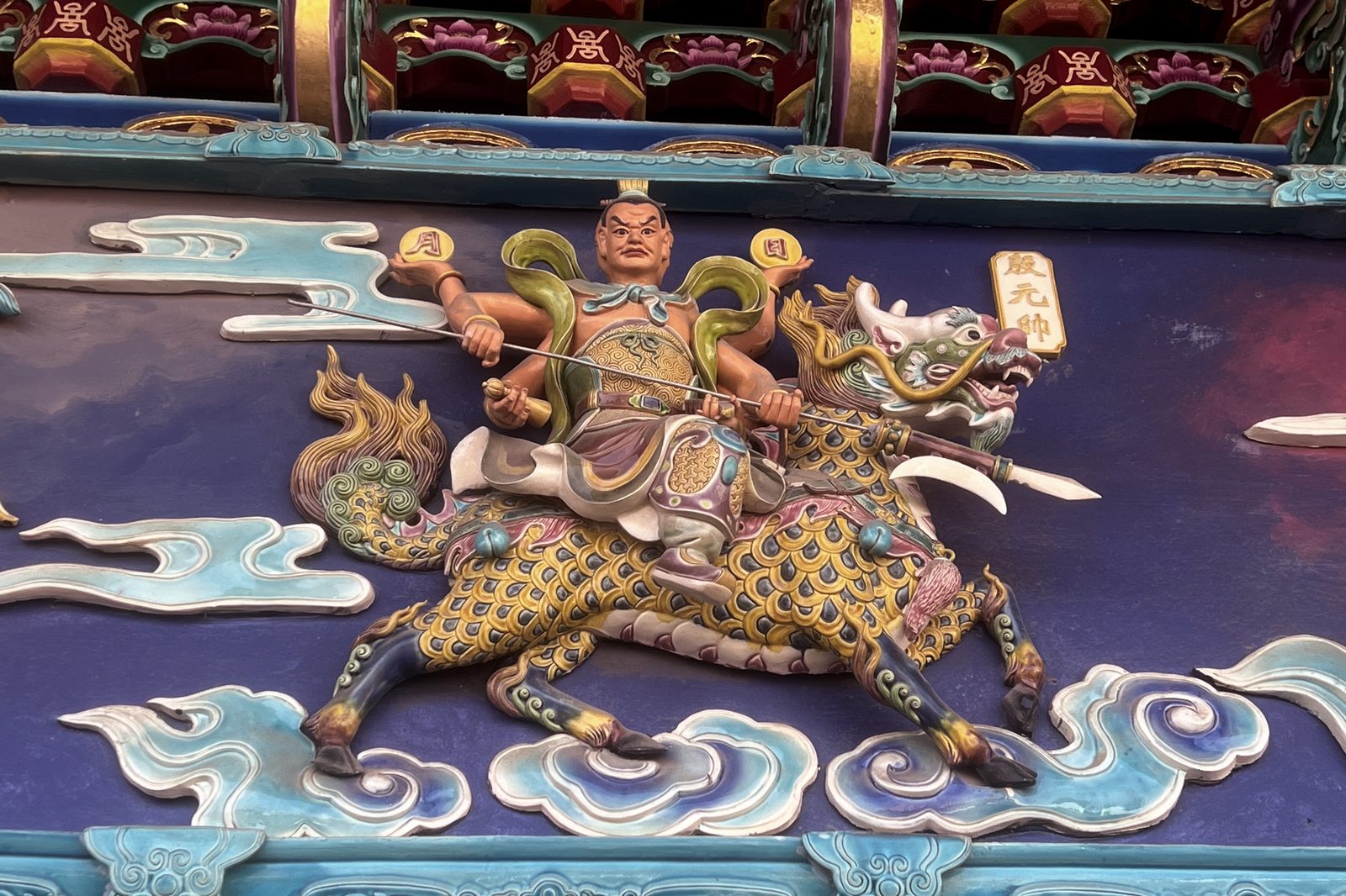 A carved temple relief of a warrior astride a qilin