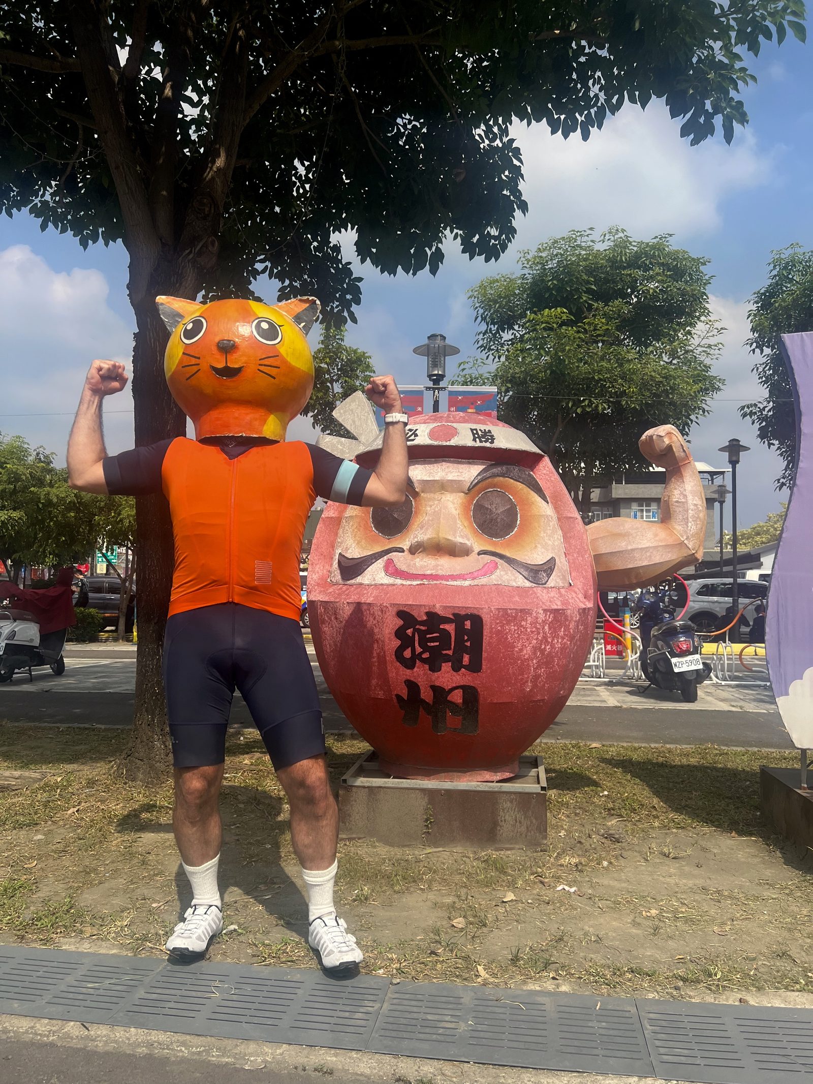 Matching the daruma's pose, cat head and all