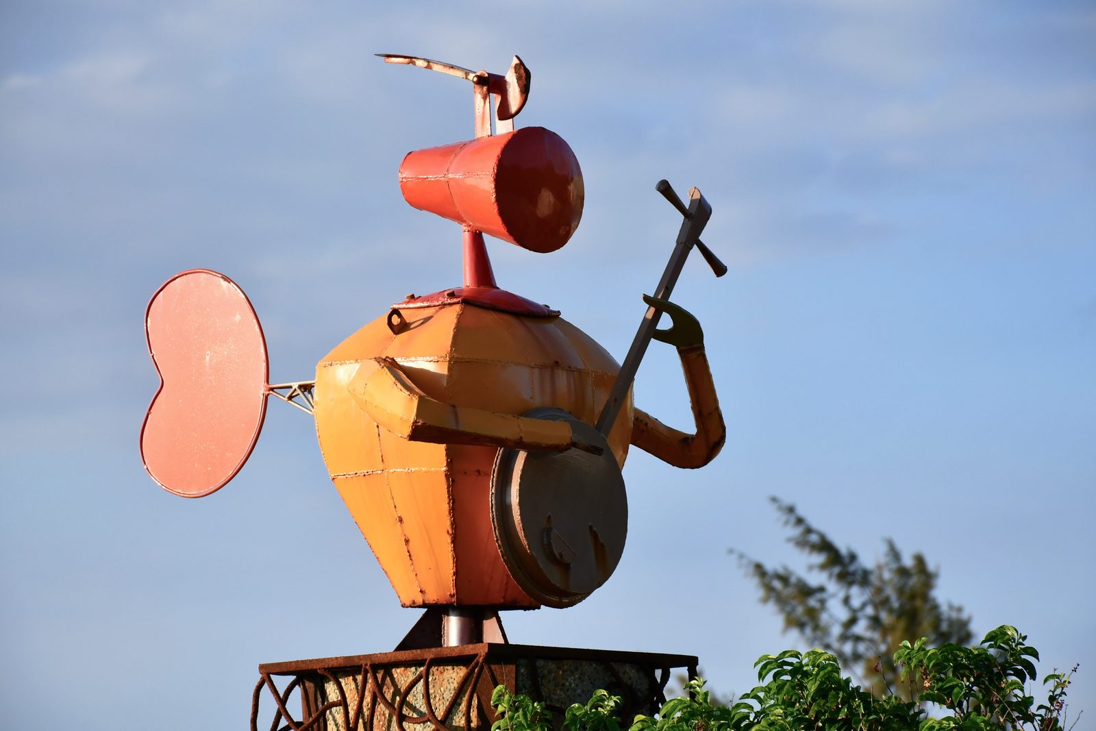 A whimsical sculpture playing a stringed instrument