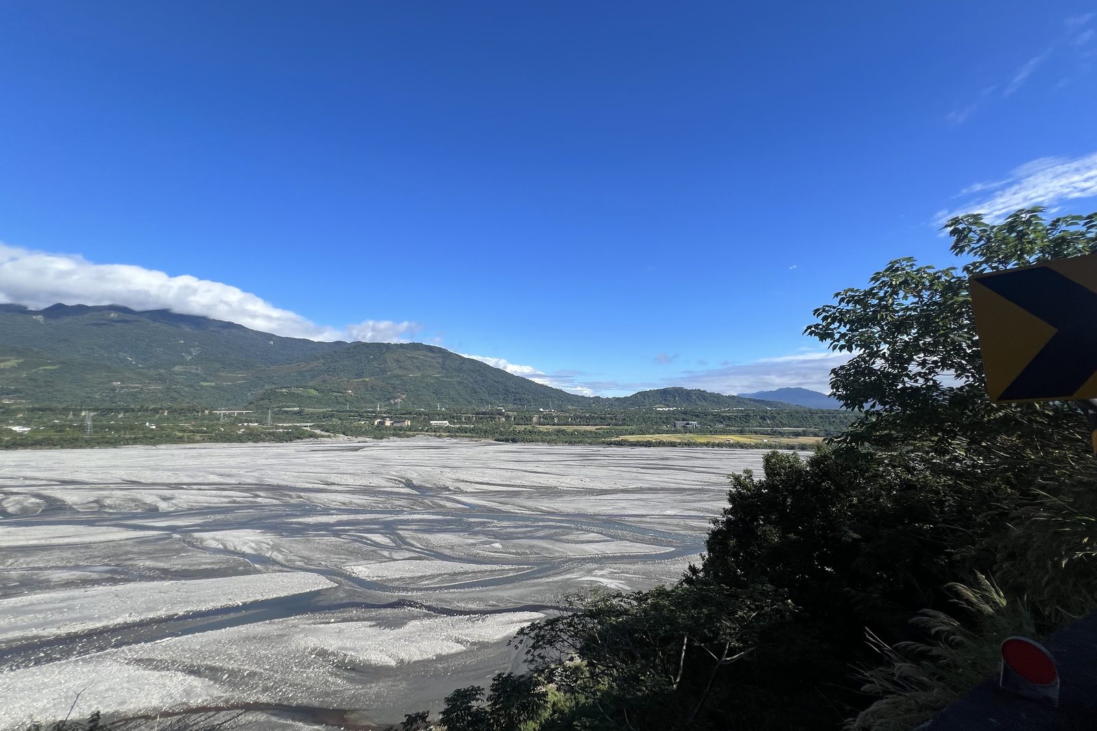 A wide gravel riverbed cutting through the valley